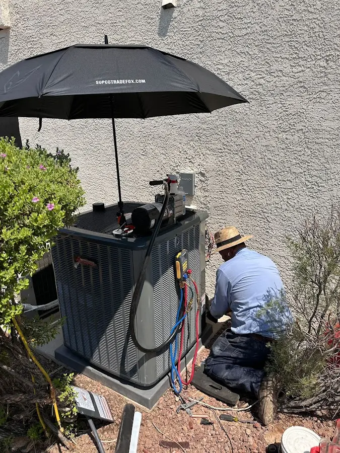 HVAC technician performing outdoor AC maintenance in White Knoll