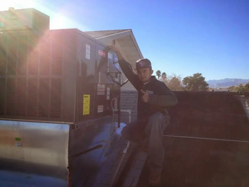 HVAC technician performing Heat Pump Repair on a rooftop unit in White Knoll